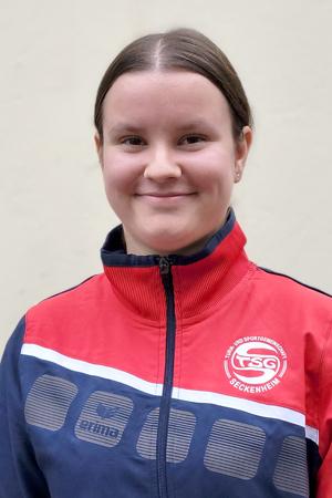 Portr&auml;t eines l&auml;chelnden M&auml;dchens in einer rot-blauen Sportjacke mit dem Logo von FSG Seckenheim.