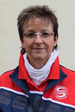 Portrait einer Frau in Sportjacke mit Logo der TSG Jeckenheim, mittellange Haare, schmaler Schal und Brille.